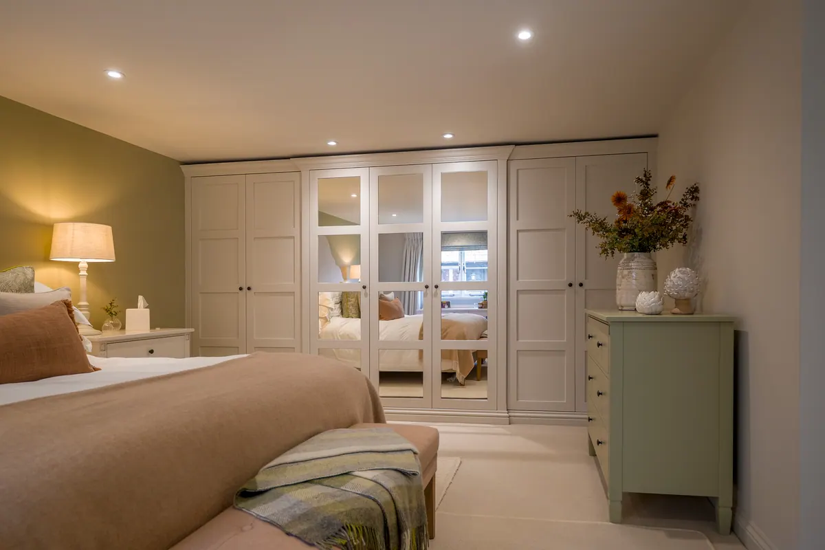 Fitted bedroom wardrobes with mirrored doors by Charles Vivian