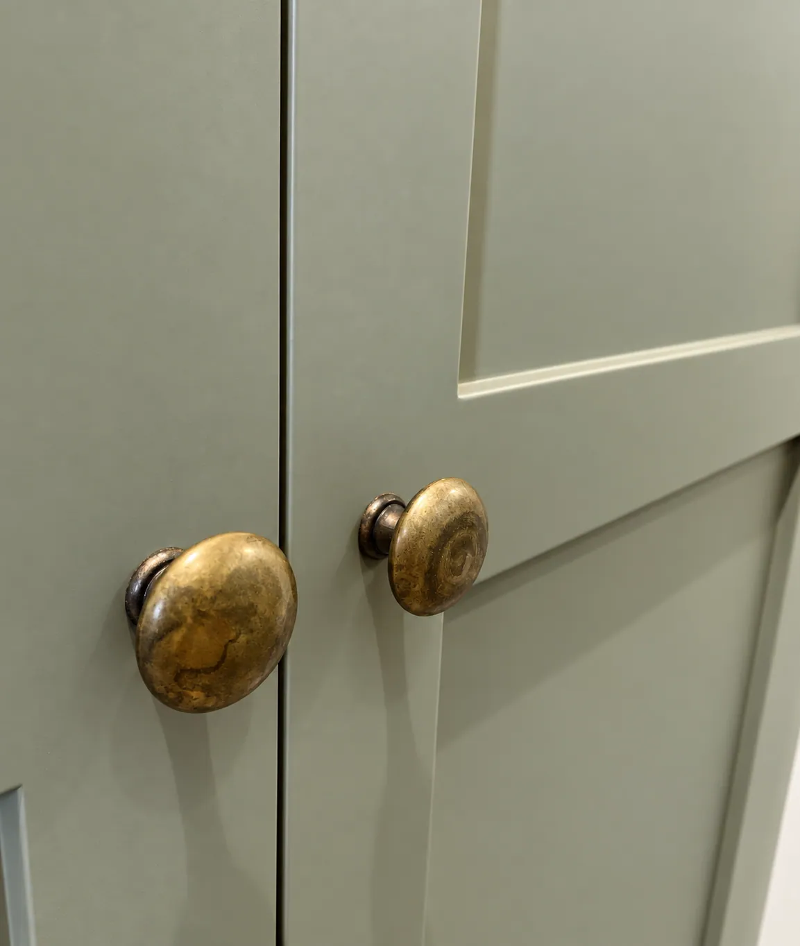 Sage-green wardrobes built into the eaves, Cambridge